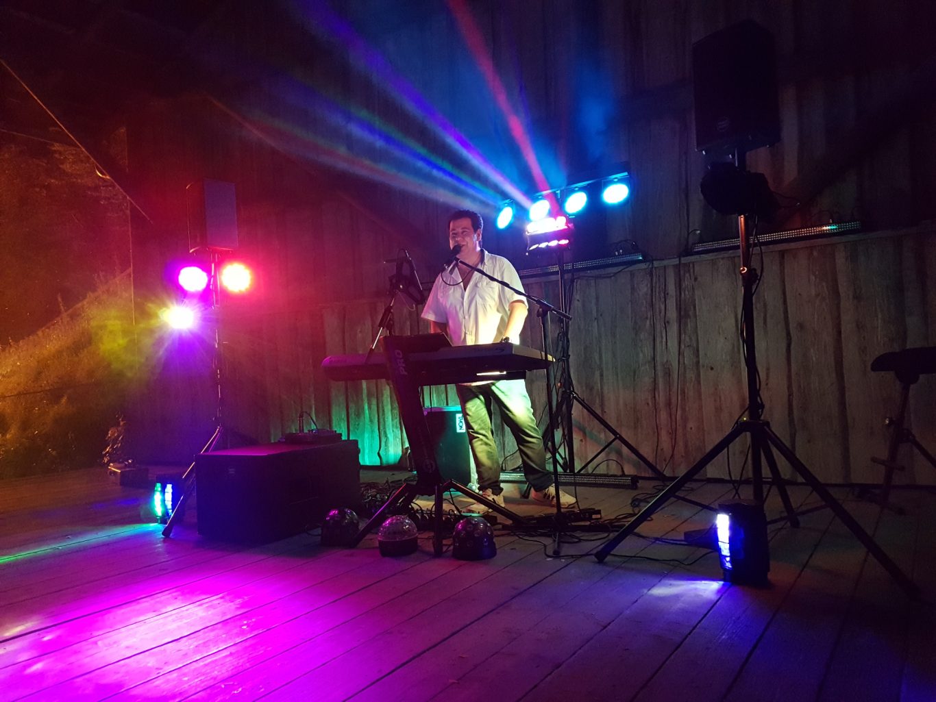 Adrian Marko Alleinunterhalter am Keyboard Ein Musiker spielt Keyboard auf einer beleuchteten Bühne in einer rustikalen Umgebung.
